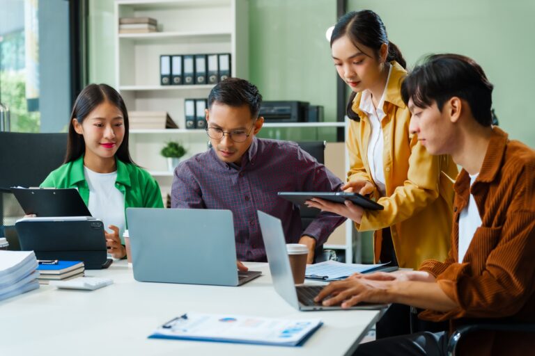 In a boardroom, an Asian team discusses startup financials and business terms.